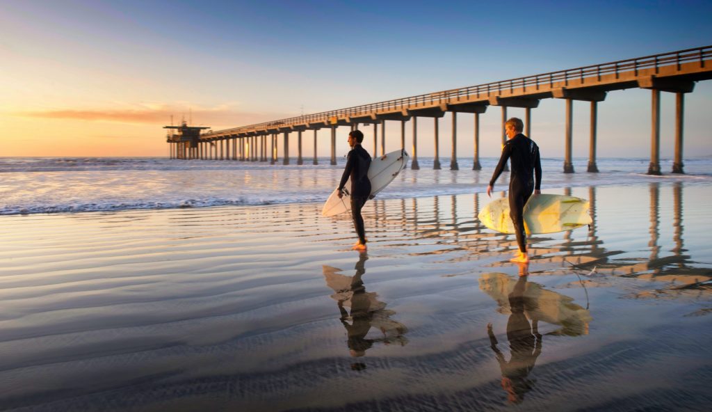 Scripps Pier with people walking to the water to surf